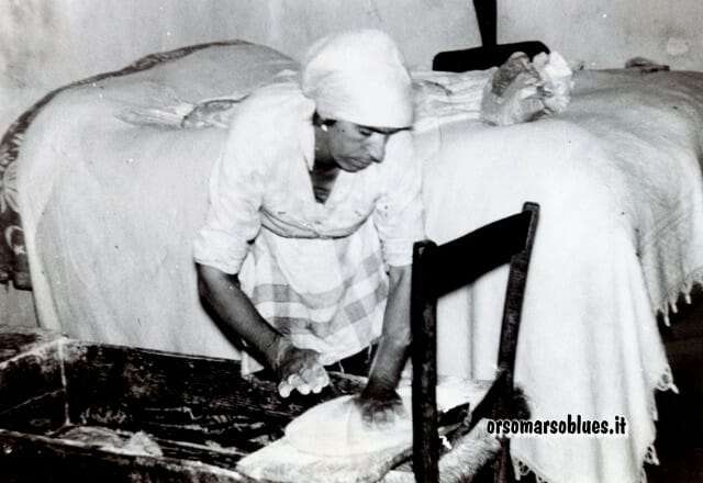 Maria Nepita, meglio nota come Maria a Piamuntisa, prepara le pagnotte sul bordo della mattra e le mette a lievitare sul letto